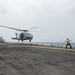 USS America Sailor signals helicopter to lift off