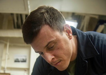 USS America Marine conducts aircraft maintenance