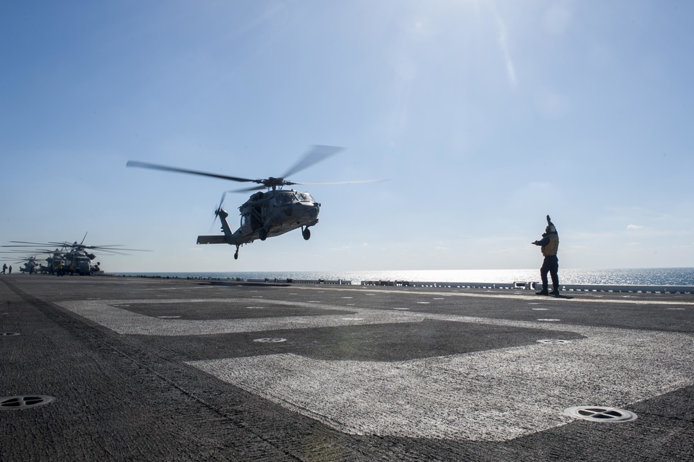 USS America Sailor signals helicopter for landing