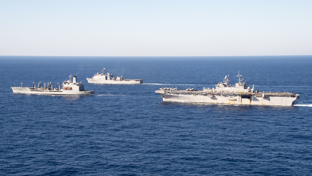 The amphibious transport dock ship USS New York (LPD 21), left, and the amphibious dock landing ship USS Oak Hill (LSD 51), right, receive fuel from the fleet replenishment oiler USNS Big Horn (T-AO 198) during a replenishment-at-sea