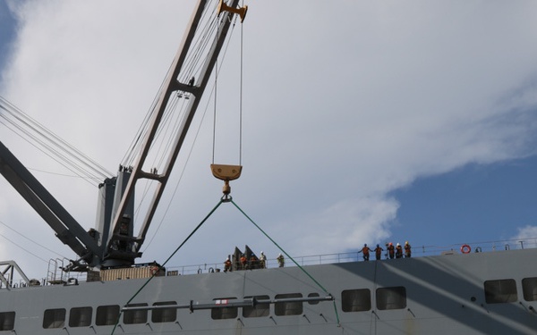 1st Armored Division Combat Aviation Brigade soldiers and USNS Brittin sailors load Chinook helicopters by crane in Ponce