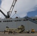 1st Armored Division Combat Aviation Brigade soldiers and USNS Brittin sailors load Chinook helicopters by crane in Ponce