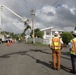 Work is completed on a power line while two U.S. Army Corps of Engineers employees observe