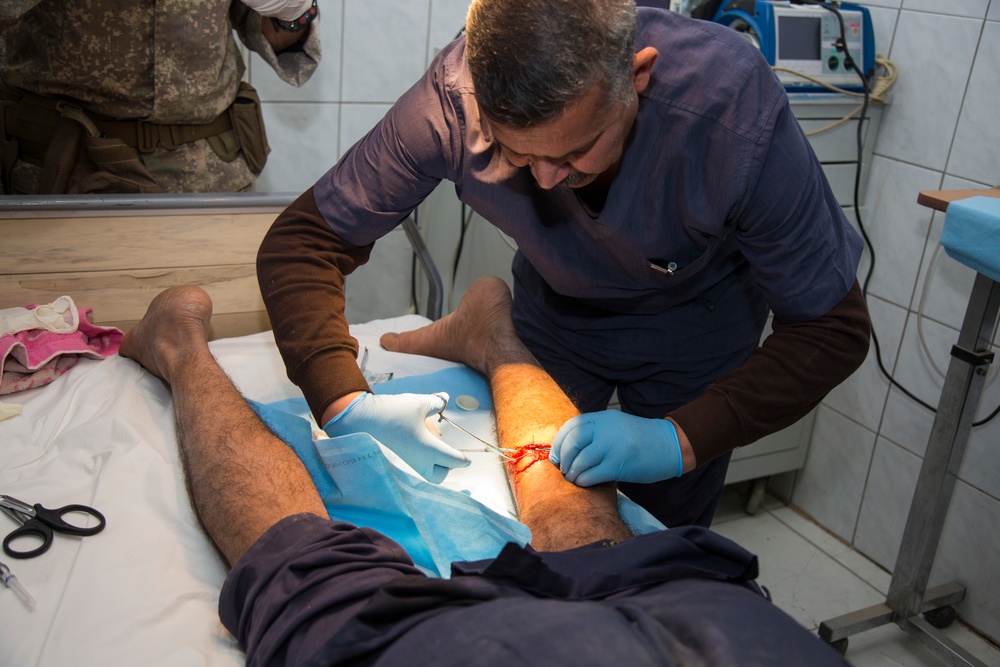 Iraqi medical staff member with Coalition support provide medical care at Taji