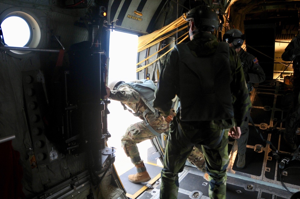 Joint crew of U.S and Swedish jumpmasters prepare to shut the doors of a U.S. Air Force C-130 Hercules after fifty-four paratroopers exited the plane