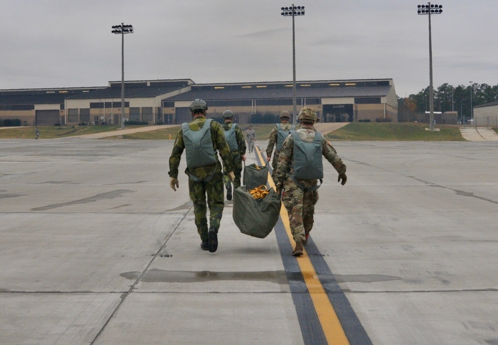 Joint crew of U.S and Swedish jumpmasters disembark a U.S. Air Force C-130 Hercules after fifty-four paratroopers exited the plane