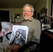 Frank McCauley smiles and holds a portrait of him in his younger years. The ace pilot passed away at 100 years old. (Courtesy photo by Perry Backus)