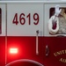 Two people dressed as Santa Claus and Mrs. Claus are riding in a United States Air Force fire truck numbered 4619. Santa is waving from the passenger window while Mrs. Claus leans out from the driver's side window, both smiling. This appears to be a holiday event or Christmas parade on a military installation.