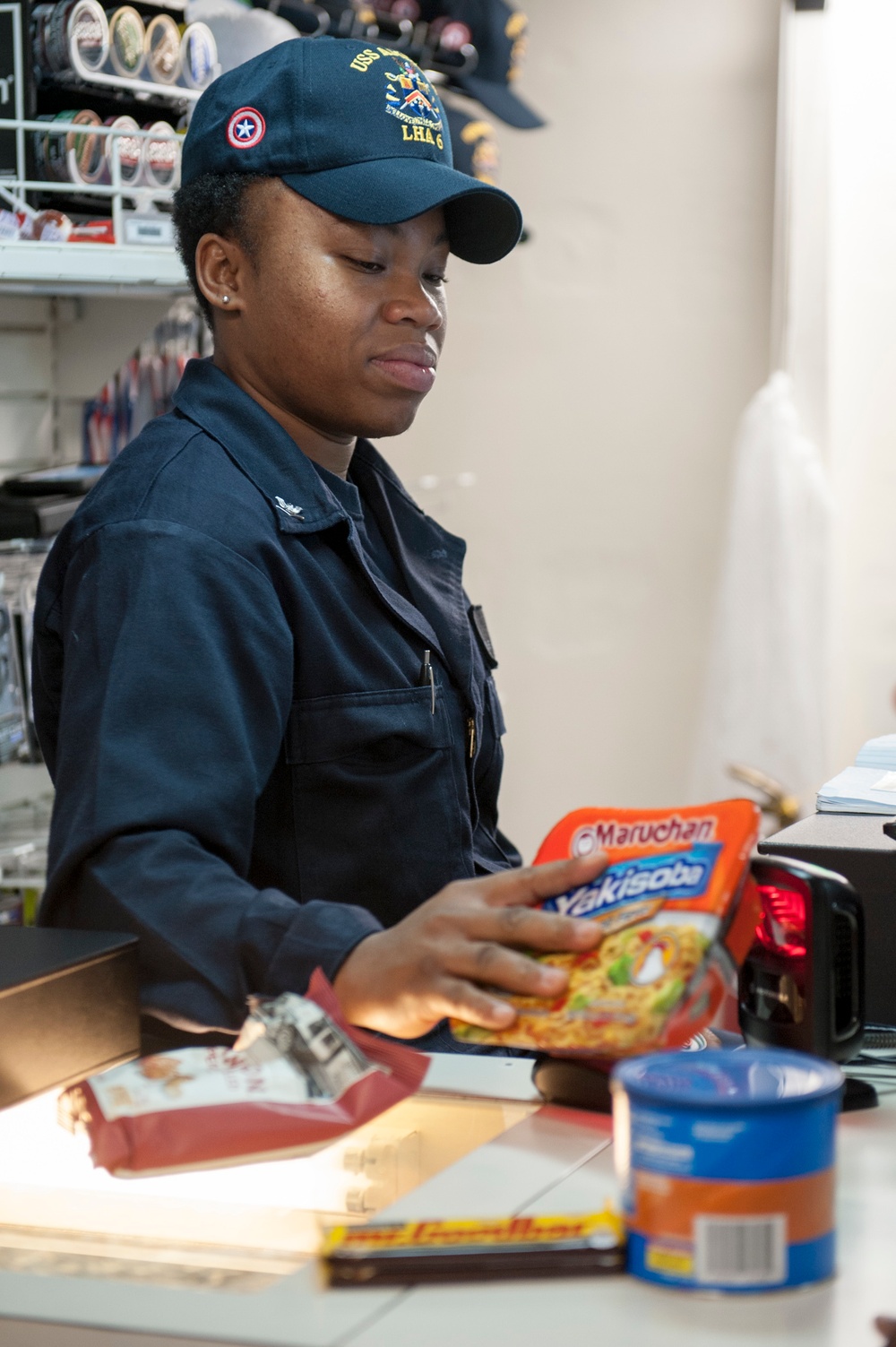 USS America Sailor scans merchandise to be sold