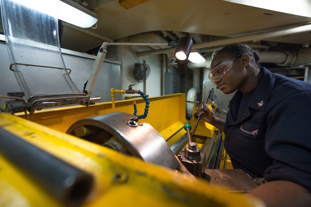 Sailor Operates Lathe