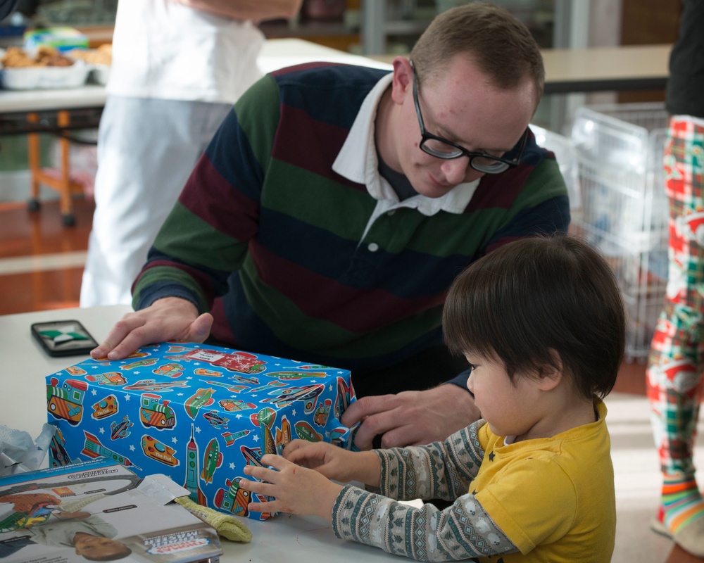 Sailor assists child in opening present