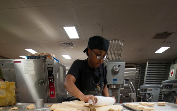 15th MEU Marine works in the bake shop on USS America