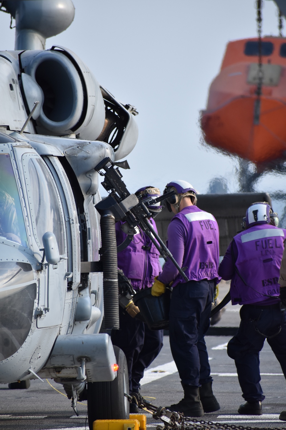 U.S. Navy Aviation Boatswains Mate Fuel (ABF) Sailors refuel an MH-60 Helicopter aboard USS Lewis B. Puller
