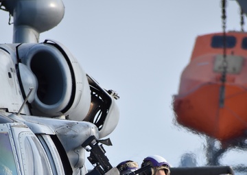U.S. Navy Aviation Boatswains Mate Fuel (ABF) Sailors refuel an MH-60 Helicopter aboard USS Lewis B. Puller