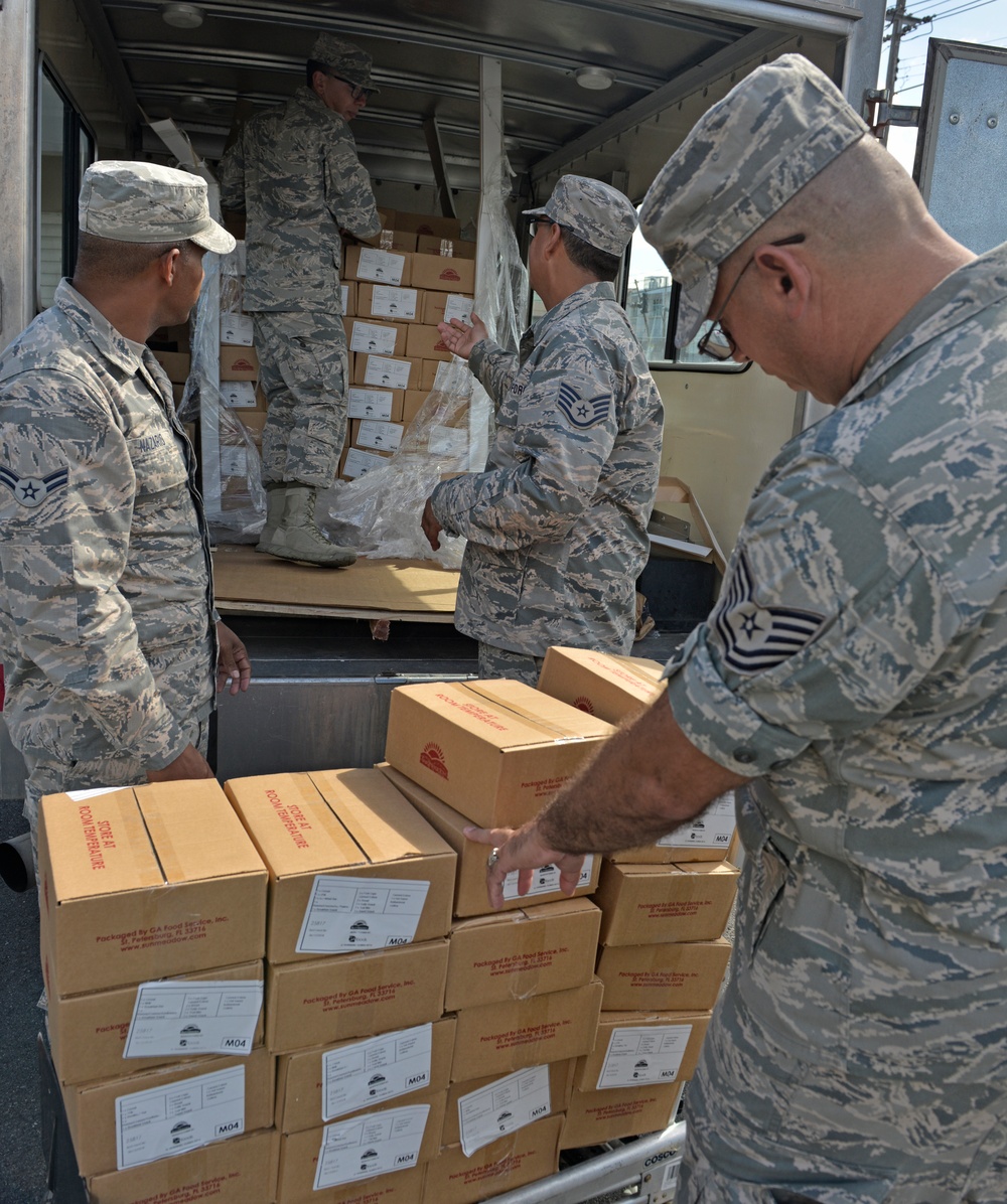 Airmen from the 156th Airlift Wing distribute food to local area children’s schools