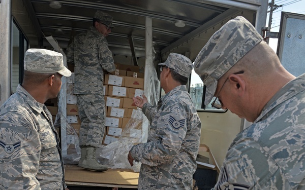 Airmen from the 156th Airlift Wing distribute food to local area children’s schools