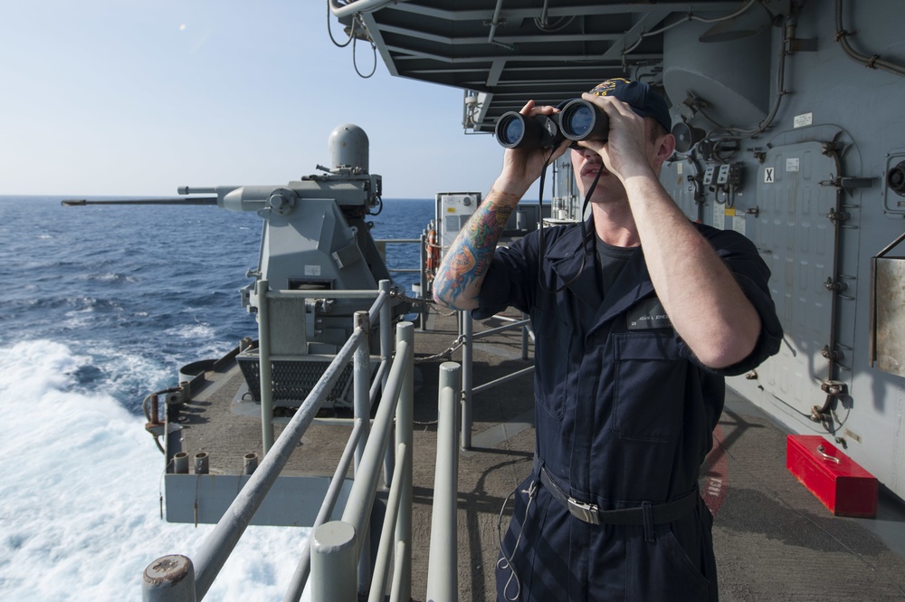 USS America (LHA 6) Sailor stands aft lookout on the fantail