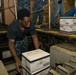 John C. Stennis Sailor Moves Boxes in Hangar Bay