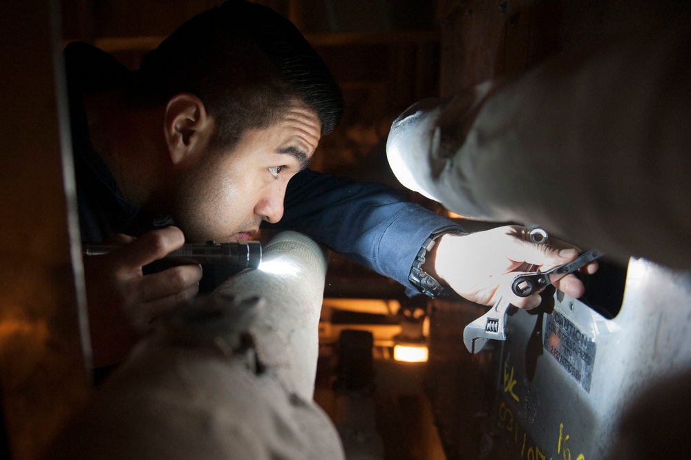 USS America (LHA 6) Sailor works on a refrigerator compressor