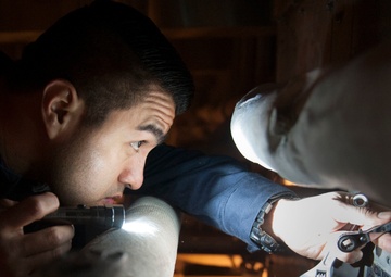 USS America (LHA 6) Sailor works on a refrigerator compressor