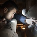 USS America (LHA 6) Sailor works on a refrigerator compressor