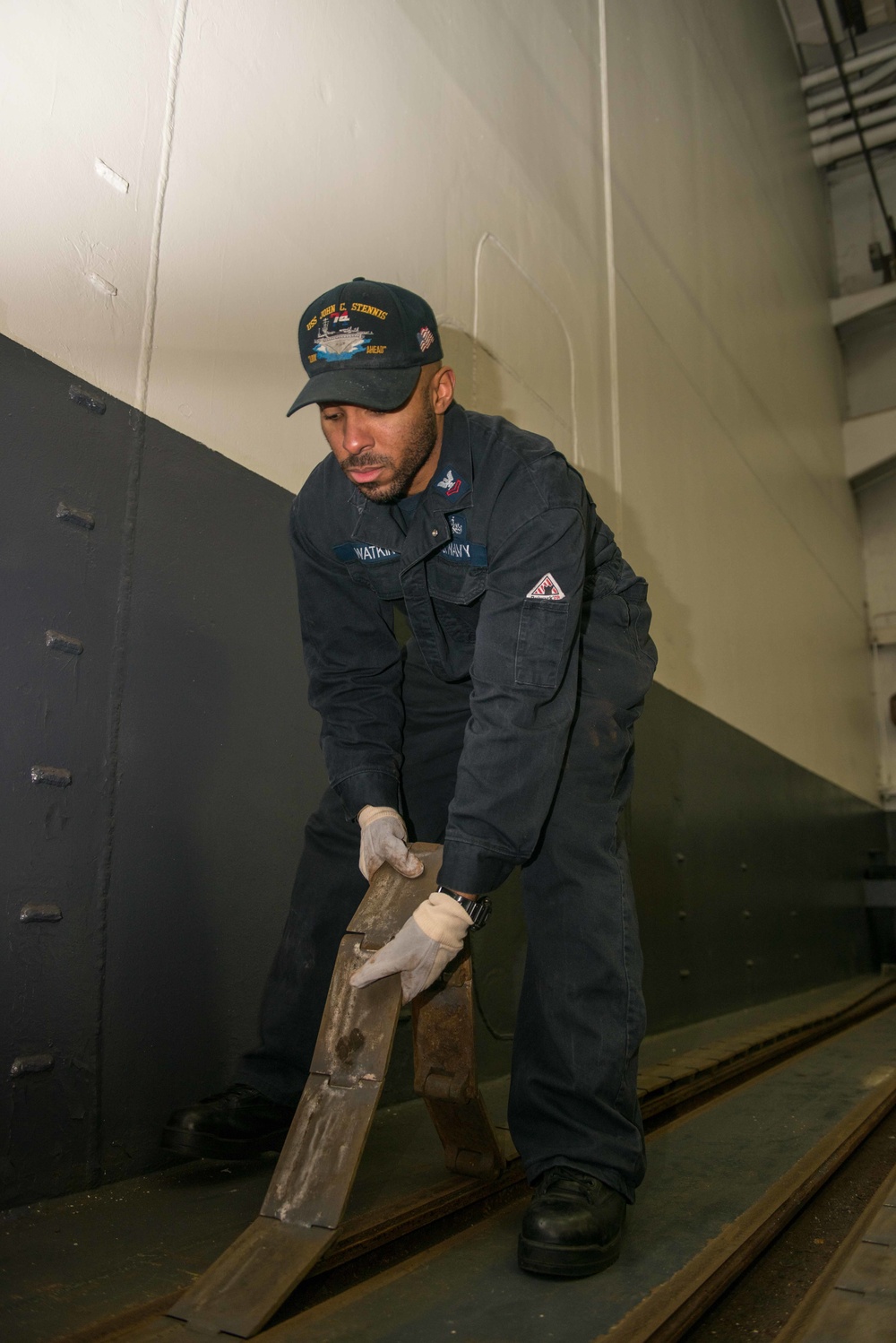 John C. Stennis Sailor Lays Down Hangar Bay Door Track