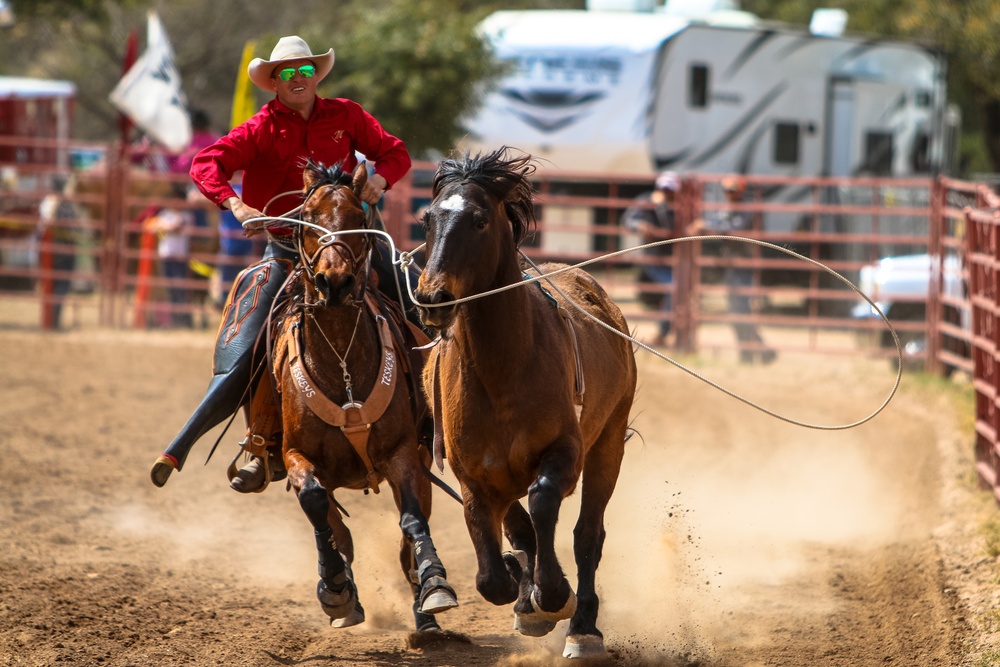 Rodeo outrider lassoes bronco