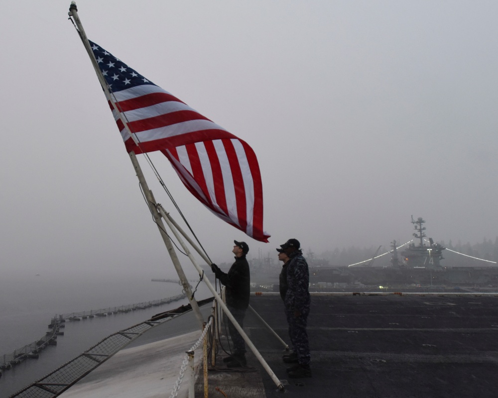 Sailors prepare to lower flag