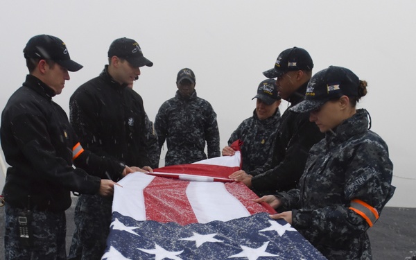 Sailors fold flag