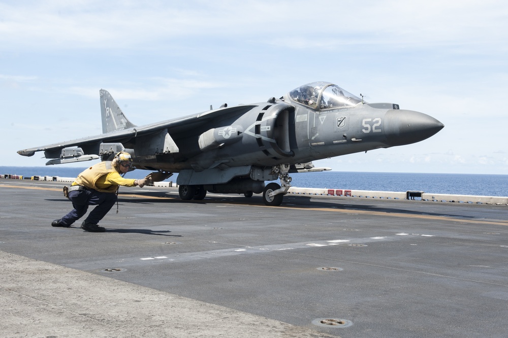 USS America Sailor signals aircraft to lift off