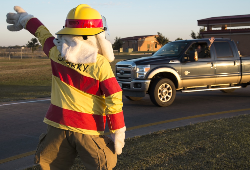 Sparky waves to passing cars during Fire Prevention Week