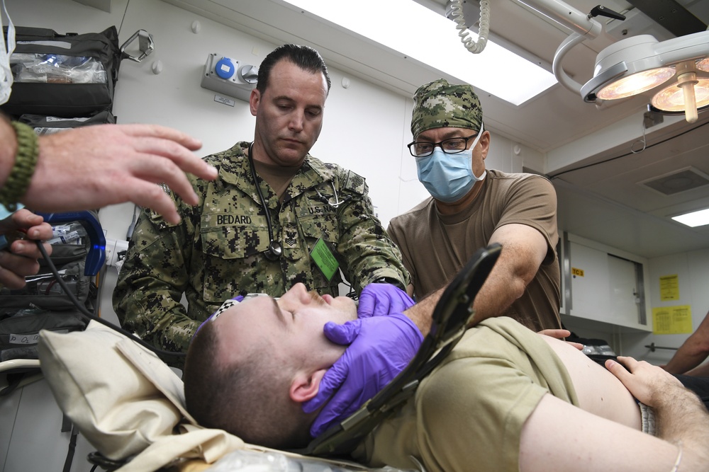 U.S. Navy and U.K. Royal Navy Sailors perform training on a Neil Robertson stretcher aboard Royal Fleet Auxiliary ship Cardigan Bay during exercise Azraq Serpent 18.