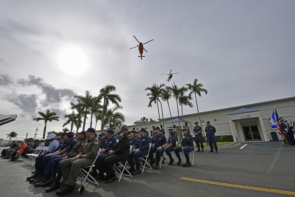 Coast Guard helicopters fly over a remembrance ceremony at Air Station Miami