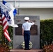 Coast Guard Air Station Miami crew member salutes after laying a wreath at memorial remembrance ceremony