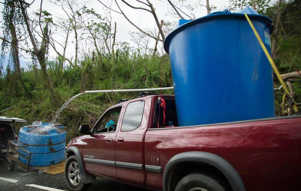 Survivors FIll Water Tanks On the Side of the Road