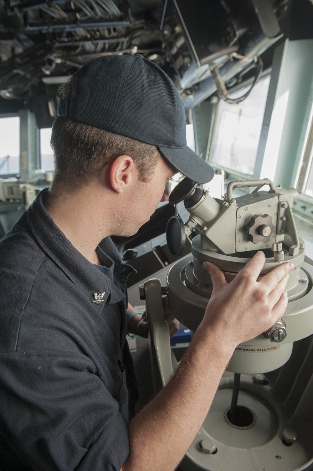 USS America (LHA 6) Sailor reads the ship's bearing using a telescopic alidade