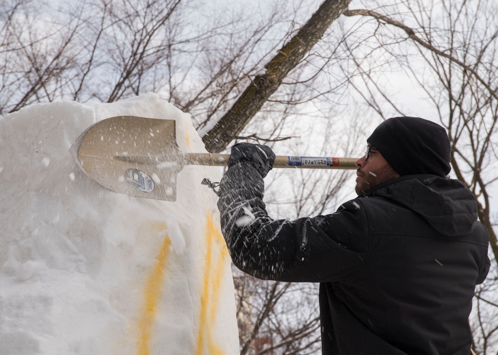 Sailor carves snow from sculpture