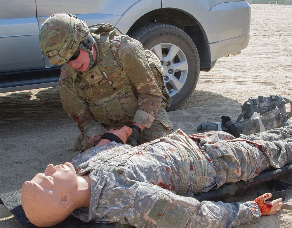 Soldier applies tourniquet to training mannequin