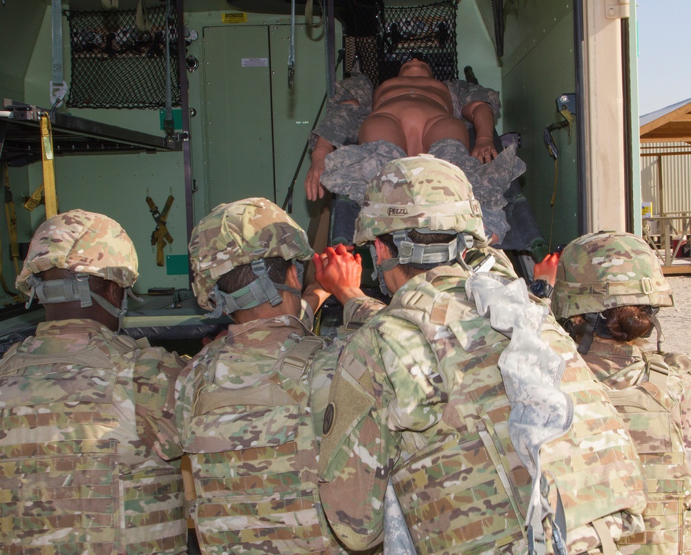 Soldiers load simulated casualty into ambulance