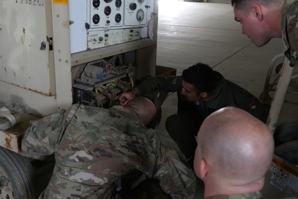 Soldiers doing maintenance on aviation ground support equipment.