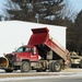 Snow-removal contractor covers icy area with sand at Fort McCoy