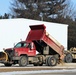 Snow-removal contractor covers icy area with sand at Fort McCoy