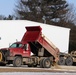 Snow-removal contractor covers icy area with sand at Fort McCoy
