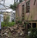 Survivor Stands in Front of His Home