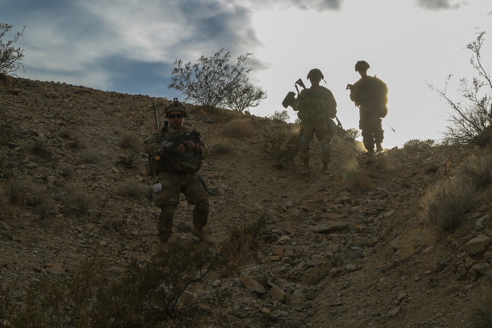 Soldiers walk down a hill from their previous observation post