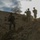 Soldiers walk down a hill from their previous observation post