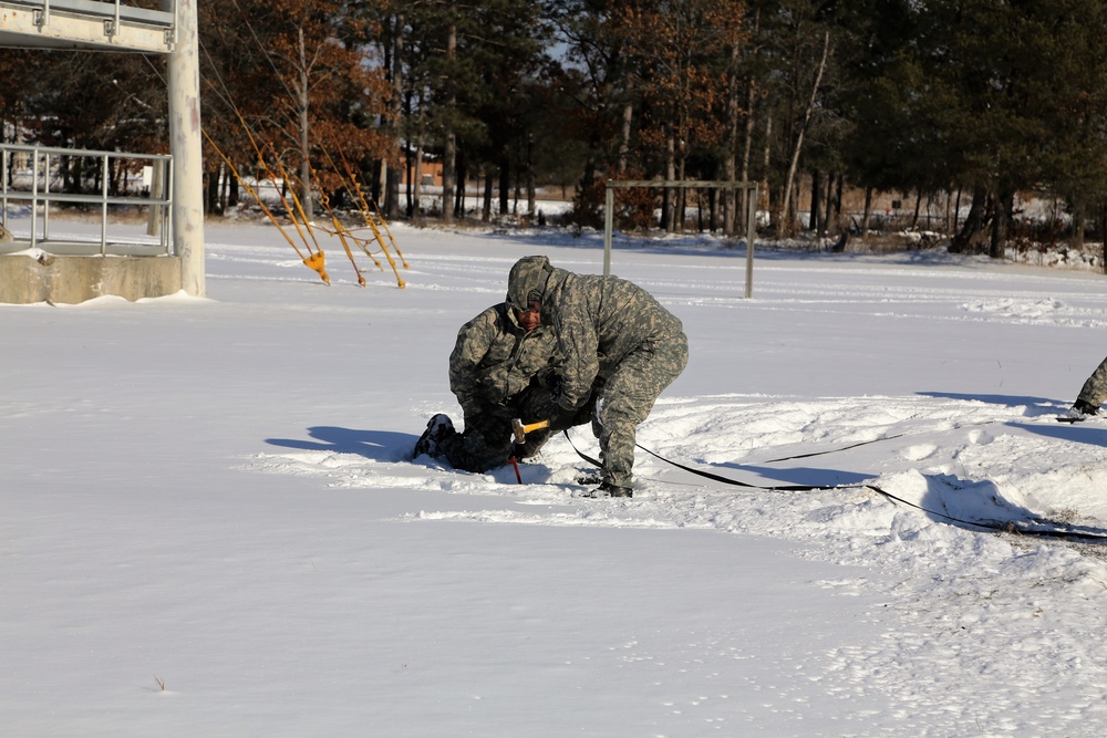 Cold-Weather Operations Course Class 18-04 students build Arctic tents during training at Fort McCoy