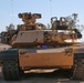 U.S. Soldiers scan the area in an M1A2 Abrams Tank