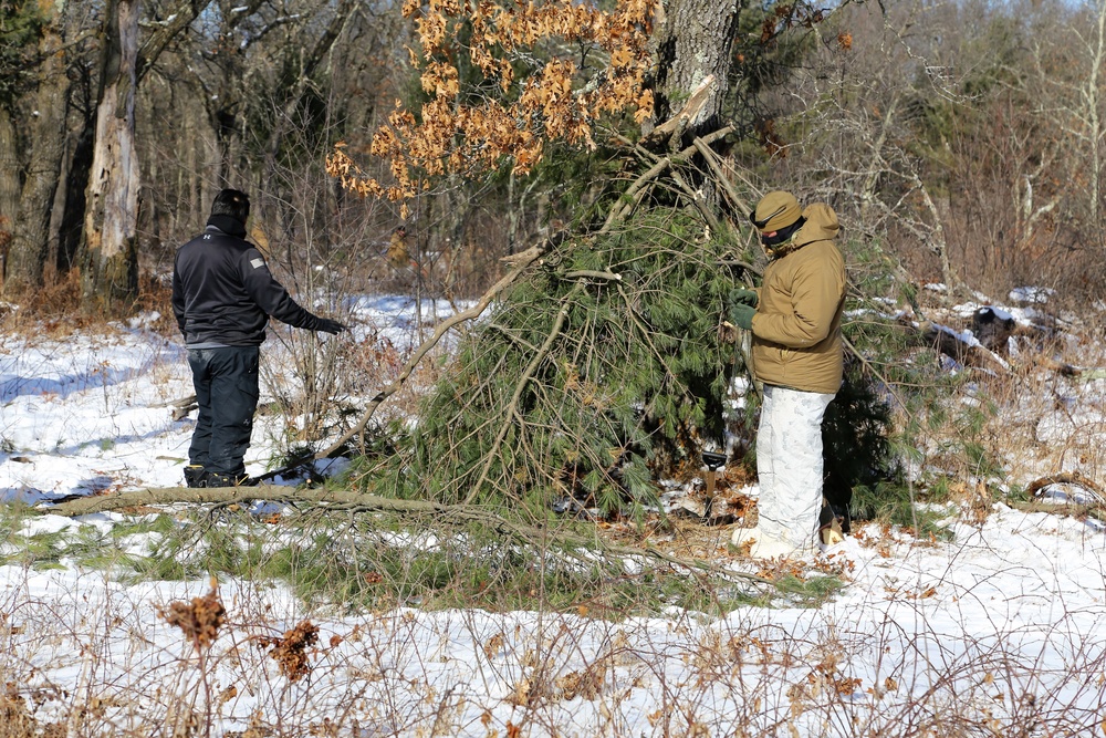 Cold-Weather Operations Course Class 18-04 students build improvised shelters during training at Fort McCoy