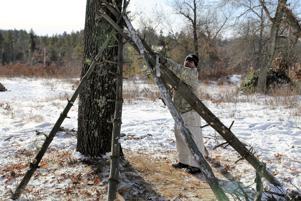 Cold-Weather Operations Course Class 18-04 students build improvised shelters during training at Fort McCoy